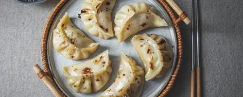 Dumplings on plate wtith chopsticks